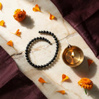 Karungali Slim Bracelet with diya and marigold — ritual flat-lay | Salico