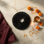 Karungali Mala with diya and marigold — ritual flat-lay | Salico