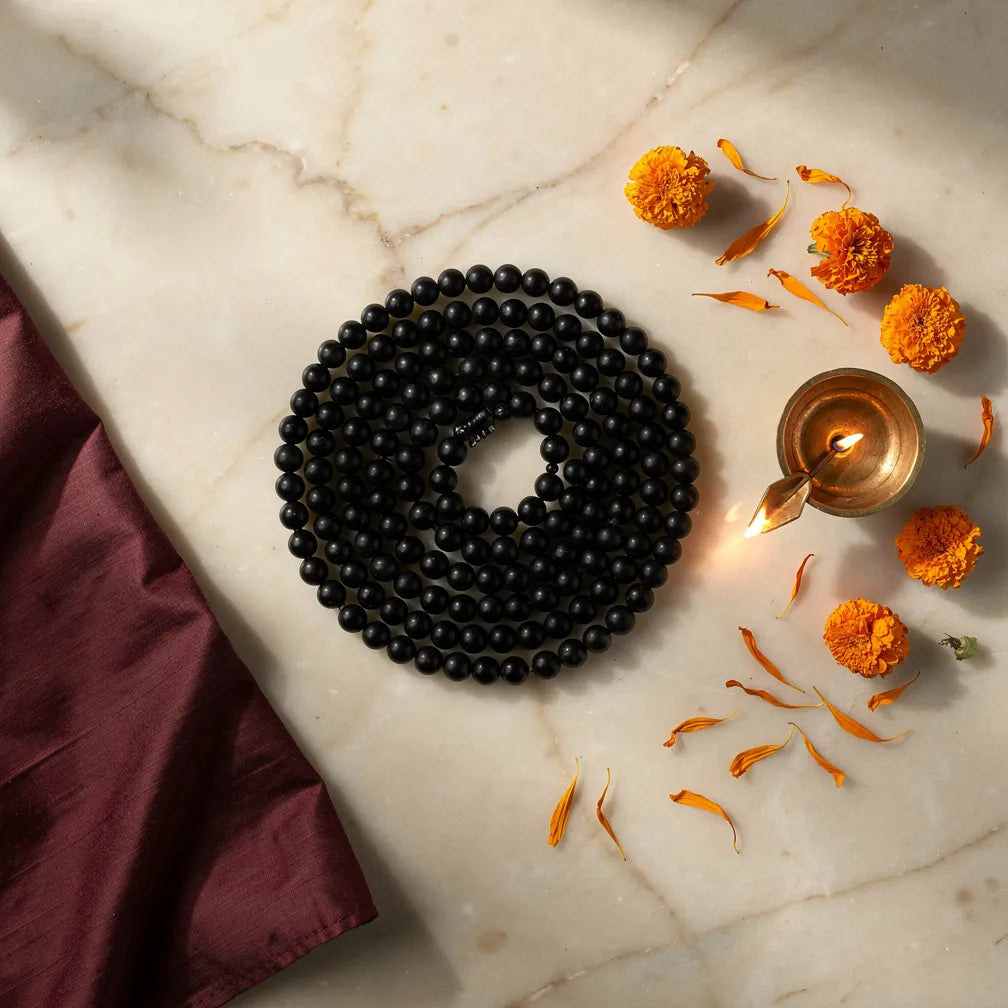 Karungali Mala with diya and marigold — ritual flat-lay | Salico