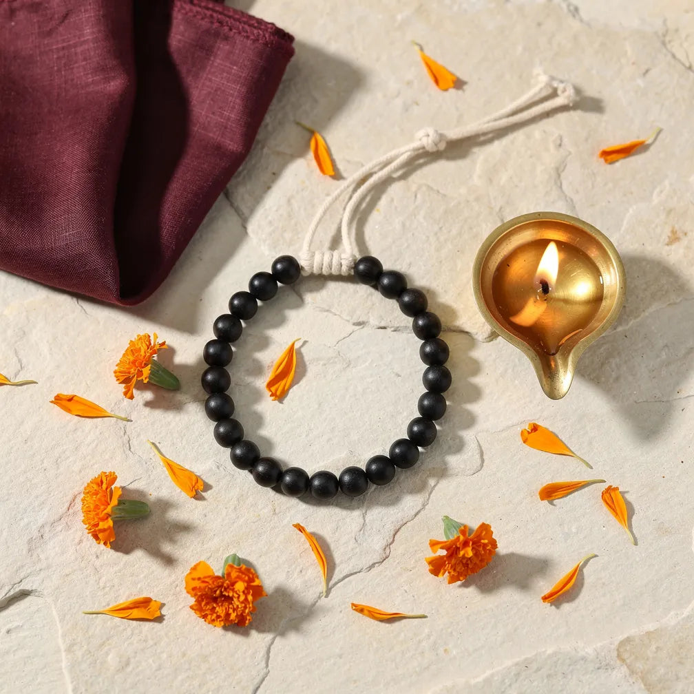 Karungali Thread Bracelet with diya and marigold — ritual flat-lay | Salico