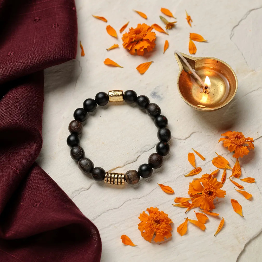 Karungali Golden Accent Band with diya and marigold — ritual flat-lay | Salico