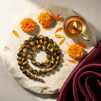 Tiger Eye Band with diya and marigold — ritual flat-lay | Salico