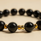 Ebony wood and gold bead texture close-up | Salico